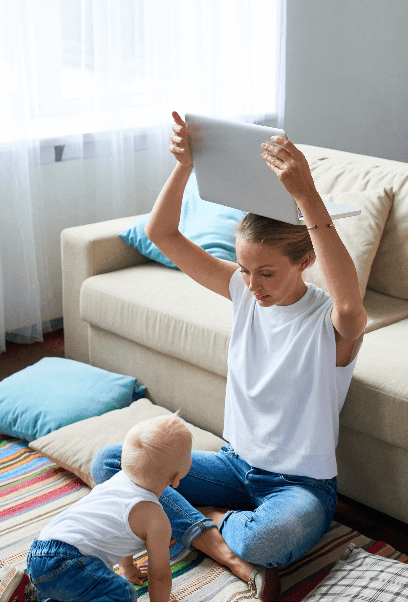 maman tient son ordi au dessus de sa tête et son bébé est à quatre pattes devant elle
